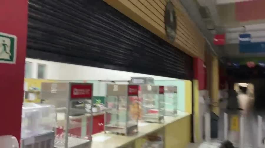 Porta de enrolar automática subindo por acionamento do motor em fachada comercial