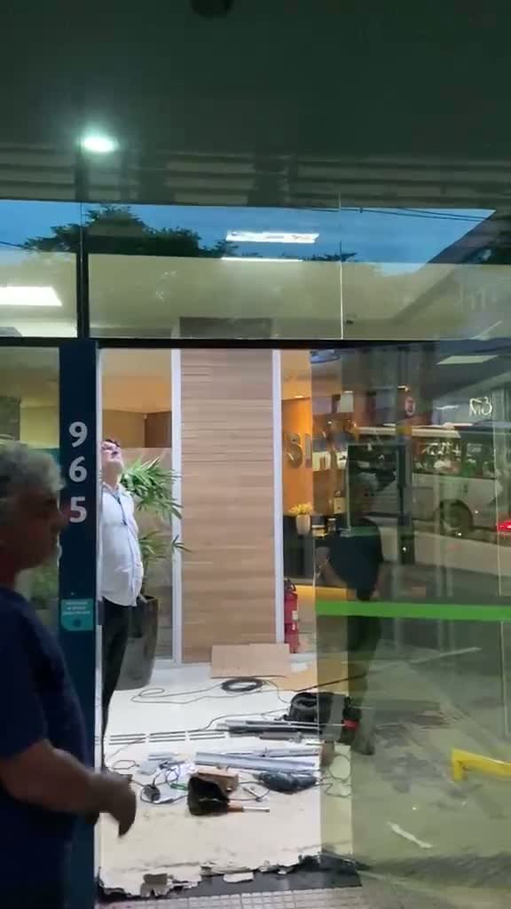 Técnico realizando manutenção no eixo e nas molas de uma porta de aço de enrolar