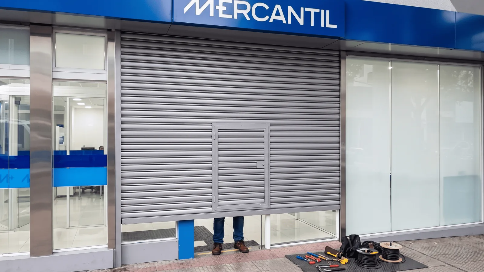 Porta de aço de enrolar compacta instalada em entrada lateral de estabelecimento
