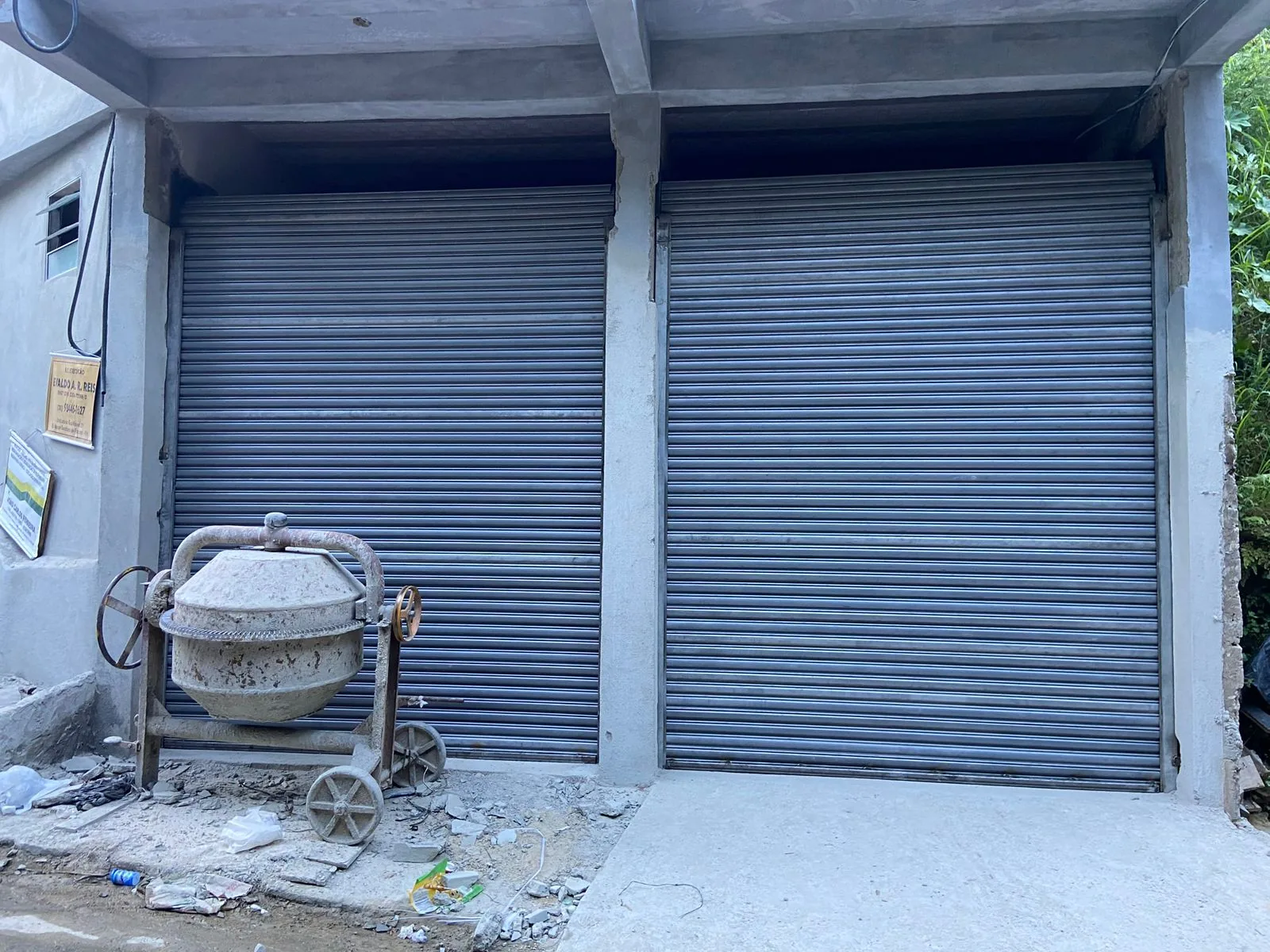 Duas portas de aço de enrolar cinza instaladas em obra nova recém-entregue